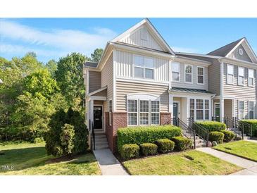 Inviting townhouse with brick and siding, featuring well-maintained landscaping and a welcoming entrance at 7838 Spungold St, Raleigh, NC 27617