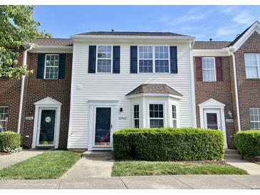 Charming townhouse featuring a well-manicured front lawn and inviting front door at 10943 Pendragon Pl, Raleigh, NC 27614
