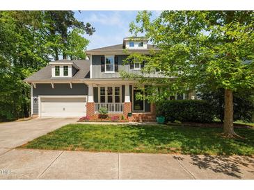 Charming two-story home featuring a brick-accented porch and attached two-car garage at 11808 Venture Oak Way, Raleigh, NC 27613