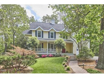 Charming two-story home with a welcoming front porch, landscaped yard, and classic architectural details at 1203 Queensbury Cir, Durham, NC 27713