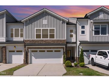 Charming townhome exterior featuring stone accents, a two-car garage, and well-maintained landscaping at 132 Deardom Way, Chapel Hill, NC 27516