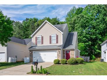 Charming two-story home featuring a two-car garage, brick accents, and manicured landscaping at 136 River Pearl St, Raleigh, NC 27603
