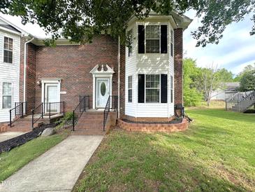 Brick townhouse with a white door, black shutters, and landscaped front yard at 208B Mallard Creek Dr, Graham, NC 27253