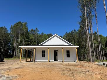 Newly constructed single story home featuring white siding and wooden support beams on the front porch at 329 Green Pines Estates Dr, Kenly, NC 27542