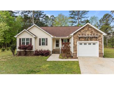 Charming single-story home with stone accents, a well-maintained lawn, and an attached garage at 35 Vauxhall Ct, Youngsville, NC 27596