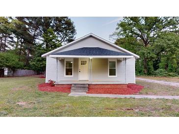 Charming home featuring a cozy front porch, gray siding, and a well-manicured lawn at 3610 Hawkins Ave, Sanford, NC 27330