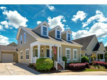 Charming two-story home featuring a welcoming front porch, dormer windows and well-manicured landscaping at 3827 Heritage Spring Circle Cir, Wake Forest, NC 27587