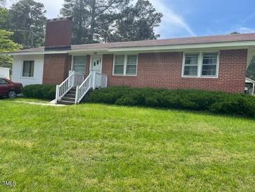 Charming brick ranch-style home with well-maintained lawn and inviting entrance at 407 N Cheatham St, Franklinton, NC 27525