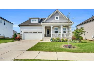 Charming home featuring a welcoming front porch and a well-maintained lawn with pretty landscaping at 4333 Benton Mill Dr, Fuquay Varina, NC 27526