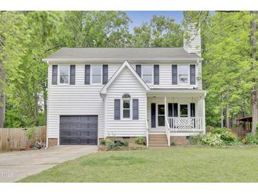 Charming two-story home with a garage, a front porch swing, and mature trees at 4711 Buttonbush Dr, Durham, NC 27712