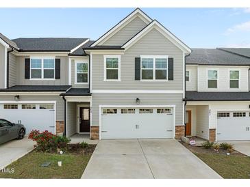 Two-story townhome featuring a two-car garage and neutral gray siding at 484 Autumn Rain St, Cary, NC 27519