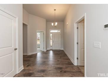 Bright entryway with hardwood flooring, a modern chandelier, and a view to a large front door at 50 Watermelon Dr, Franklinton, NC 27525