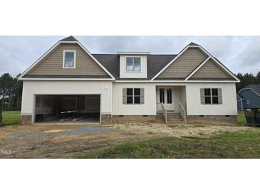 Charming new construction with a two-car garage, inviting front porch, and a mix of white and brown exterior at 65 Sanders Farm Dr, Smithfield, NC 27577