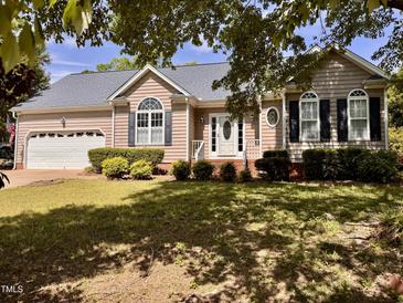 Charming single-story home with manicured lawn, attached garage, and inviting front entrance at 6715 St Johns Ct, Raleigh, NC 27616