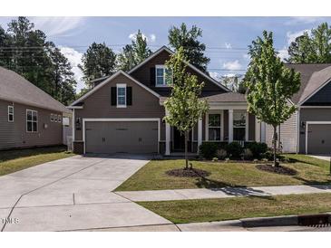 Charming home featuring a two-car garage, well-maintained lawn, and beautiful curb appeal at 1242 Underbrush Dr, Durham, NC 27703