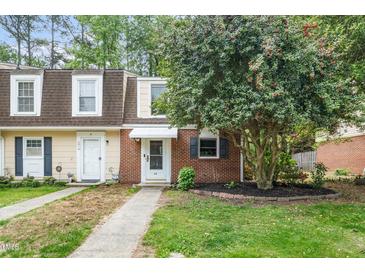 Charming townhouse featuring brick accents, dormer windows and a well maintained front yard and walkway at 13 Patriot Cir, Durham, NC 27704