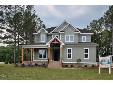 Charming two-story home with a welcoming porch and beautifully landscaped front yard at 15 Independence Dr, Smithfield, NC 27577