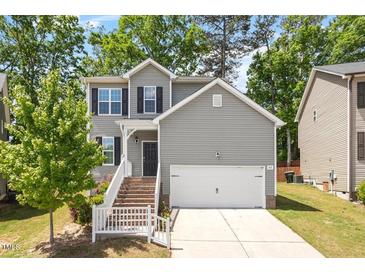 Charming two-story home with gray siding, white trim, landscaped front yard, and attached two-car garage at 162 W Lumber Ct, Clayton, NC 27520