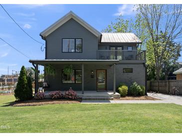Charming two-story home featuring a gray exterior, covered porch, and well-manicured lawn at 310 Georgetown Rd, Raleigh, NC 27608