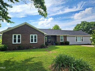 Charming single-story home with brick and vinyl siding, a well-manicured lawn, and a classic welcoming entrance at 3785 Little Creek Church Rd, Clayton, NC 27520