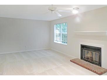 Bright living room features a fireplace, large window and neutral carpet at 403 Gooseneck Dr # A-1, Cary, NC 27513