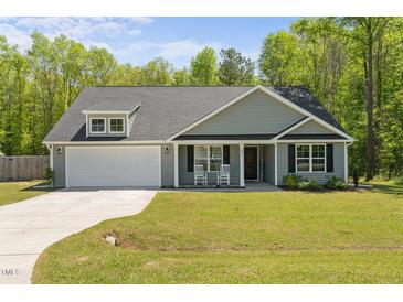 Charming single-story home with a well-manicured lawn and inviting front porch with rocking chairs at 479 Kotata Ave, Bunnlevel, NC 28323