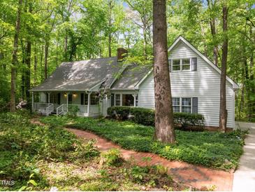 Charming home featuring a welcoming front porch, lush landscaping, and a brick path leading to the entrance at 608 Valen Ct, Chapel Hill, NC 27516