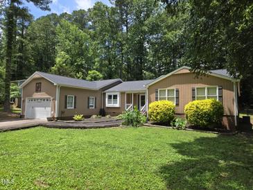 Charming home with landscaped yard, mature trees, and two car garage at 725 Van Thomas Dr, Raleigh, NC 27615