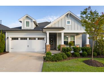 Charming single Gathering home featuring a two-car garage and a welcoming front porch at 825 Flower Manor Dr, Wendell, NC 27591