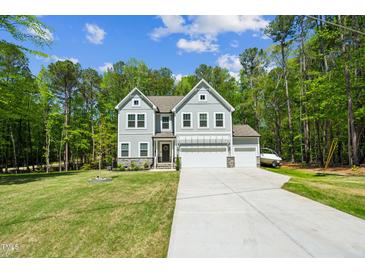 Charming two-story home with a three-car garage, well-manicured lawn, and beautiful, mature trees at 101 Yuma Dr, Louisburg, NC 27549