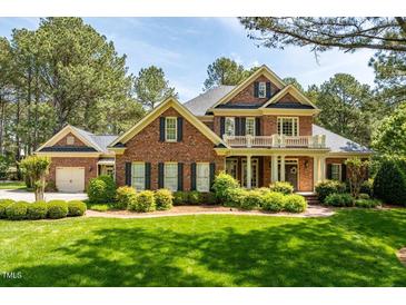 Beautiful two-story red brick home featuring a second story balcony and well-manicured front yard at 1317 Colonial Club Rd, Wake Forest, NC 27587