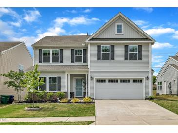 Charming two-story home featuring a two-car garage, well-manicured lawn, and inviting front porch at 1410 Arena Ln, Fuquay Varina, NC 27526