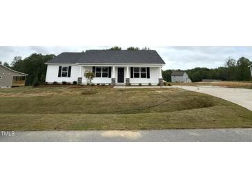 Charming single-story home with white siding and a well-manicured lawn on a cloudy day at 146 Starry Sky Dr, Benson, NC 27504