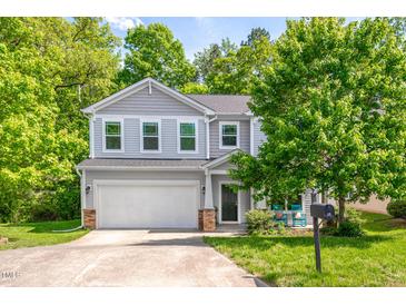 Charming two-story home featuring a two-car garage and a cozy front porch with inviting rocking chairs at 15 White Spruce Ct, Durham, NC 27703