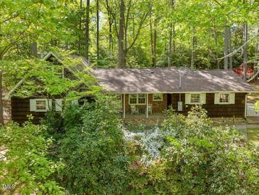 Charming single-story home with brick accents, white shutters, and a beautifully landscaped front yard at 203 Wood Cir, Chapel Hill, NC 27514
