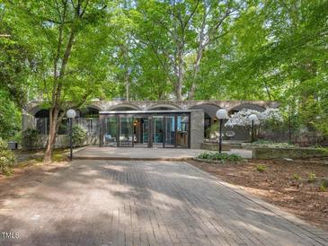 Stunning modern home with unique architecture, featuring a brick driveway and lush greenery at 205 Wood Cir, Chapel Hill, NC 27514