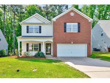 Charming two-story home featuring a well-maintained lawn and a two-car garage at 217 Carolina Town Ln, Holly Springs, NC 27540