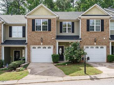 Charming townhouse with brick facade, black shutters, and single-car garage, surrounded by lush landscaping at 23 Great View Ct, Clayton, NC 27527