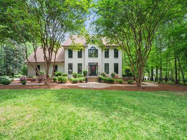 Charming two-story white brick home with a landscaped yard and mature trees enhancing its curb appeal at 2312 Laurelford Ln, Wake Forest, NC 27587
