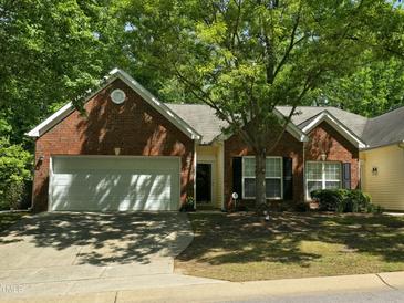 Charming brick home featuring an attached two-car garage and lush landscaping at 2565 Bent Green St, Raleigh, NC 27614