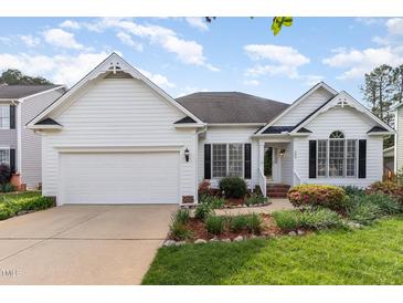 Charming one story home boasts a manicured lawn, attached garage, and classic white siding at 300 Ravenstone Dr, Cary, NC 27518