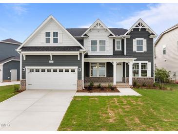 Charming two-story home featuring a two-car garage, manicured lawn, and a mix of gray siding and white trim at 3529 Bailey Lake Dr, Fuquay Varina, NC 27526