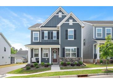 Charming two-story home with a welcoming front porch and manicured landscaping at 361 Natsam Woods Way, Wake Forest, NC 27587