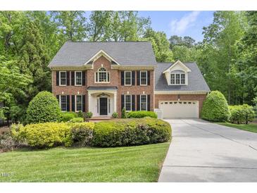 Charming brick home featuring black shutters, a well-manicured lawn, and a two car garage at 408 Evert Dr, Cary, NC 27511