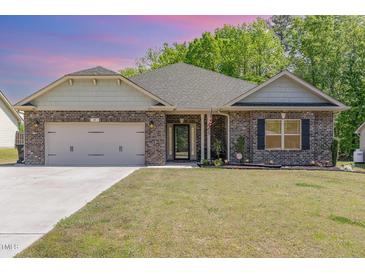 Charming brick home with a well-manicured lawn and an attached two-car garage at 49 Parkside Dr, Lillington, NC 27546