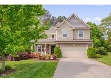 Charming two-story home with a well-manicured lawn, flowering shrubs, and an attached two-car garage at 504 Applecross Dr, Mebane, NC 27302