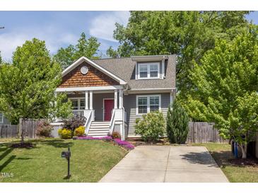 Charming home with a red door, beautiful landscaping, and a well-maintained lawn at 507 Canal St, Durham, NC 27701