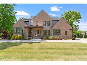 Stunning brick home featuring professionally landscaped front yard and a symmetrical front elevation at 5803 Vintage Oak Ln, Raleigh, NC 27613