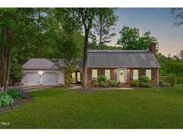 Charming brick home with a lush green lawn and a welcoming two-car garage at 615 Beaver Creek Rd, Apex, NC 27502
