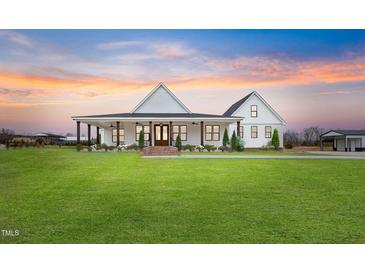 Stunning modern farmhouse with a large front yard, inviting porch, and charming architectural details at 6185 Nc-50, Benson, NC 27504